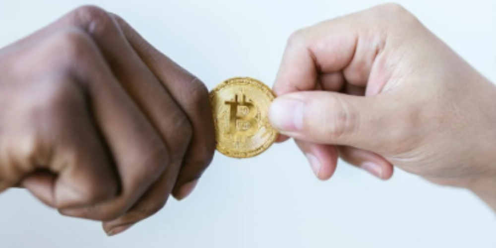 two hands holding bitcoin using for online gambling