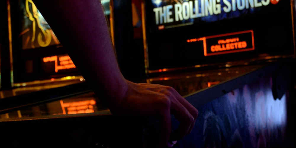 music pinball themes represented with someone playing The Rolling Stones themed pinball