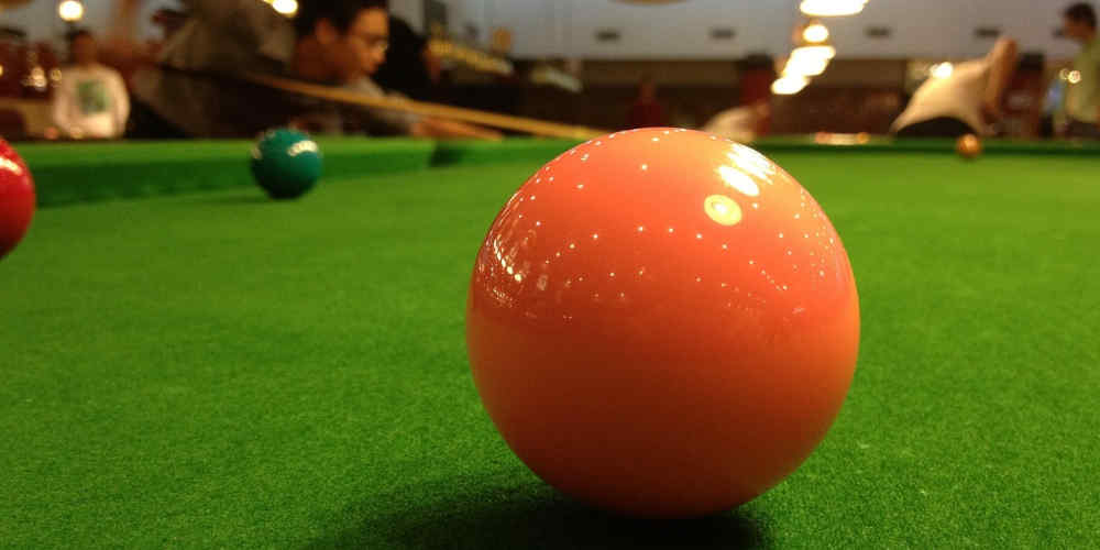 online snooker betting represented with snooker ball in the spotlight on a table